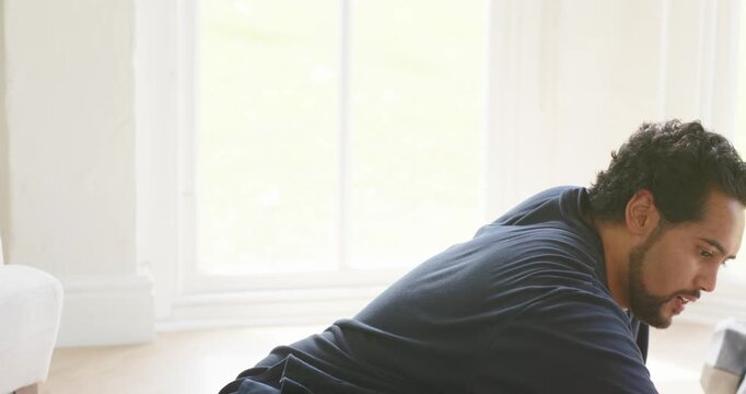 African American 30s man grabbing dark green bottle, leaning and twisting cap to open at home