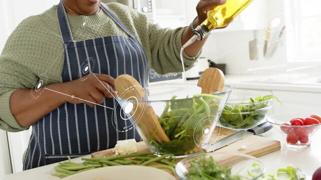 Home cook picking oil bottle, pouring, dressing and tossing salad in glass bowl with HUD overlaying