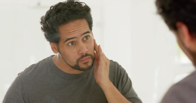 Seeing bathroom mirror, African American mid-adult man touching cheek, smoothing beard for grooming