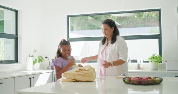 Diverse family helping child packing backpack in kitchen, hugging, child holding bottle for school