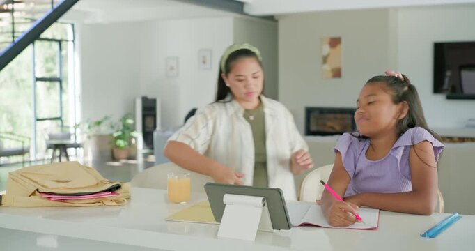 African American child pointing to sofa urging Asian carer helping with homework at kitchen island