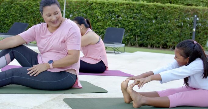 Diverse women stretching on pool mats youth starting fold causing woman turning checking watch