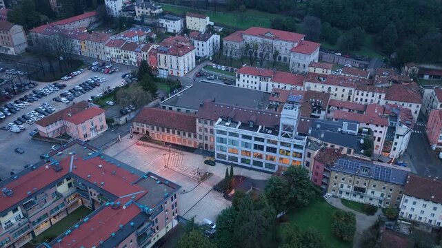 Aerial drone footage featuring a smooth pullback combined with rotation from Lanificio Conte, revealing the skyline of Schio in Vicenza, Italy.