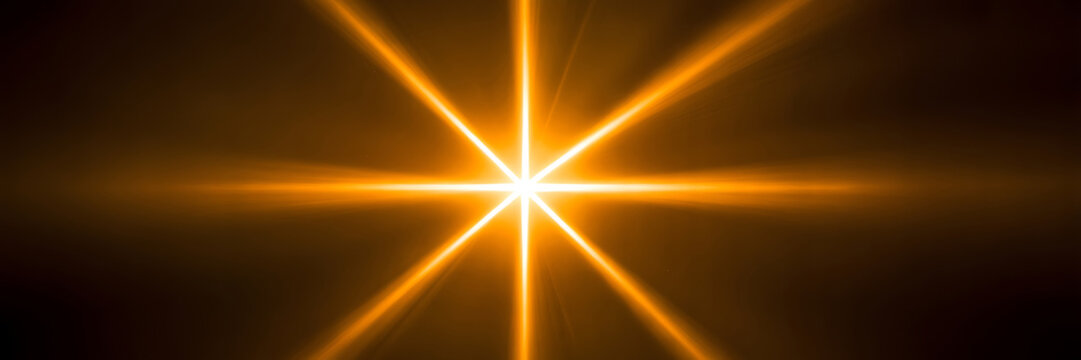 A bright shining star with vibrant orange light rays in darkness