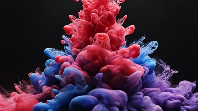 Abstract colorful ink swirls in water forming vibrant clouds against a dark black background.