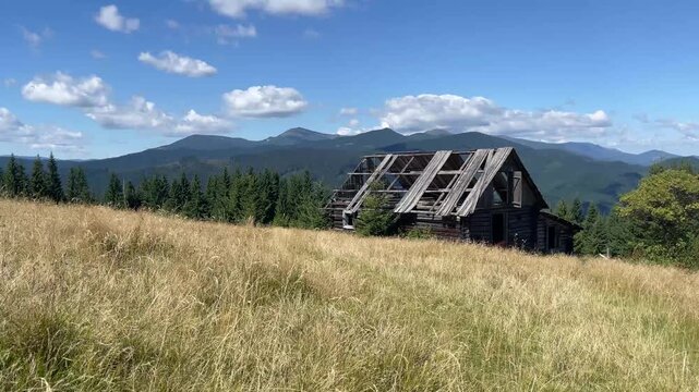 Mountain hills with Abandoned Wooden house green grass waving