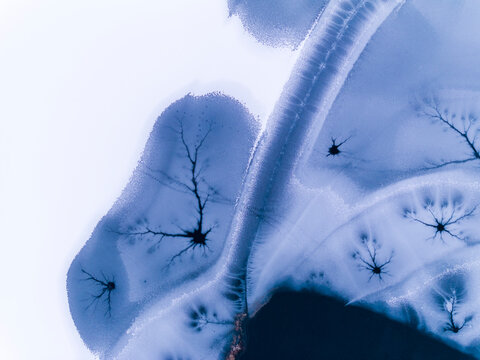 Landscape, tourism: Aerial view of frozen lake with ice patterns resembling trees, winter environment, Fusine lakes, Tarvisio, Friuli, Italy.