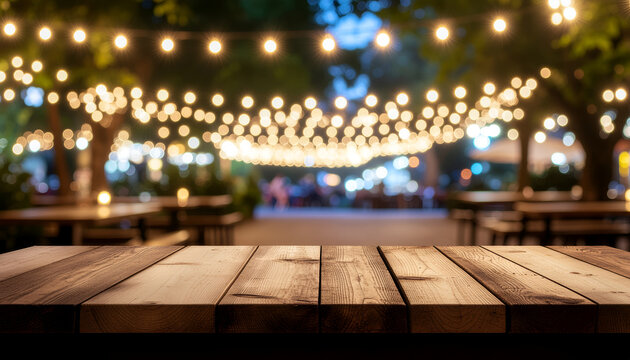 Rustic wooden table with bokeh string lights in outdoor evening garden.