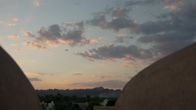 Slow Motion View Between Nizwa Fort Buttress Walls at Sunset, Cinematic Omani Oasis and Mountain Horizon