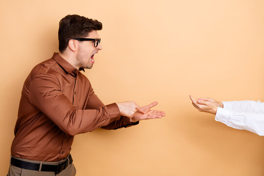 Angry man yelling and pointing at outstretched hand during a tense confrontation and disagreement