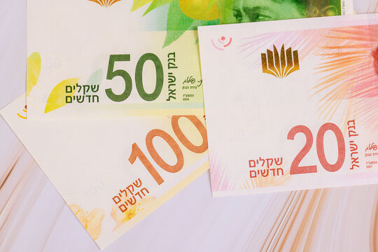 Three types of New Israeli shekel money are laid out on surface. banknotes of 20, 50, 100 shekels