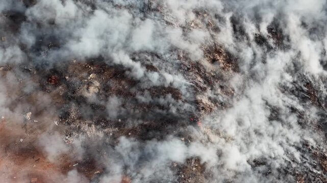 Aerial drone view of landfill fire burning waste from above