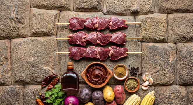 Overhead flat lay of Anticucho skewers ingredients on Incan stone wall