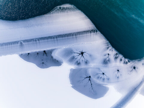 Winter landscape, aerial view of frozen lake with ice patterns, creating a unique nature background, Fusine lakes, Tarvisio, Friuli, Italy.