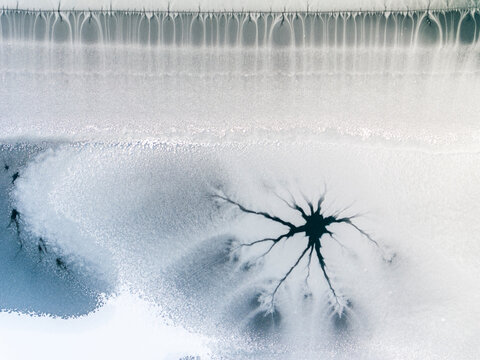 Winter landscape, aerial view of frozen lake with ice crack pattern, nature background, Fusine lakes, Tarvisio, Friuli, Italy.