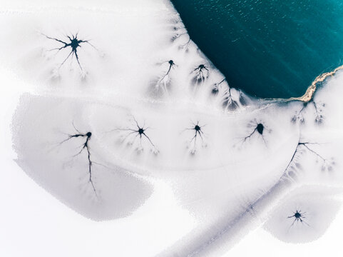 Winter landscape, aerial view of frozen lake with cracks, ice texture, nature background, Fusine lakes, Tarvisio, Friuli, Italy.