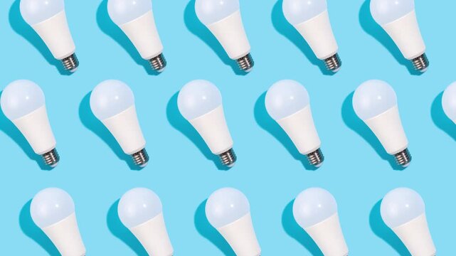 Modern LED light bulbs arranged in a repeating pattern on a vibrant blue background