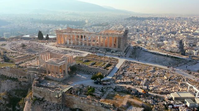 Aerial drone view of Parthenon on Acropolis in Athens, Greece. Detailed ancient ruins with cityscape in background, iconic historical landmark.
