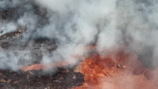 Aerial drone view of burning landfill and smoke plumes