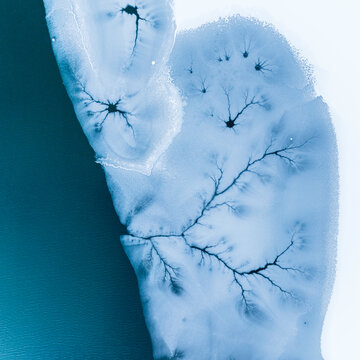 Winter landscape, aerial view of frozen lake with ice patterns, representing nature and destination concept. Fusine lakes, Tarvisio, Friuli, Italy.
