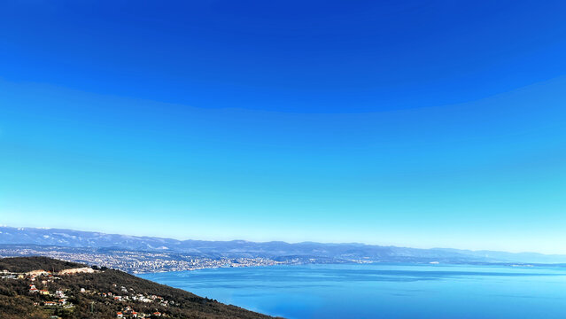 Panoramic view of Kvarner Bay, Rijeka, and Krk island from Ucka mountain, Croatia, with large blue sky copy space.