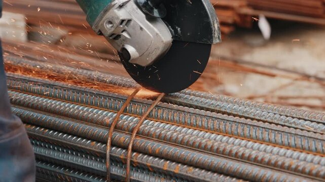 Cutting steel rebar with angle grinder producing sparks close up