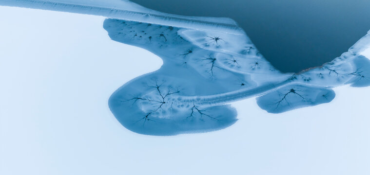 Winter landscape, aerial view of frozen lake and snow-covered mountains, tourism and destination concept, Fusine lakes, Tarvisio, Friuli, Italy.
