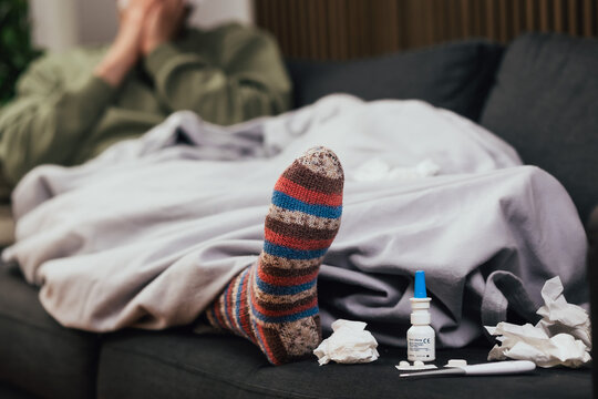 Mann mit Schnupfen auf der Couch