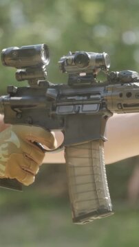 Soldier firing AR-15 rifle at outdoor range during daytime