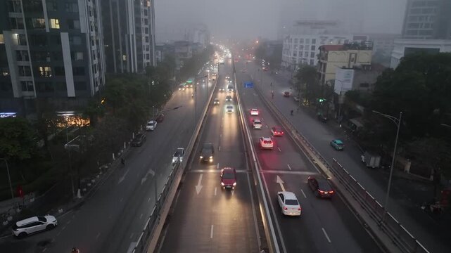 Aerial view of divided highway on Minh Khai street during foggy morning with buses, cars, and motorbikes moving through low visibility conditions.