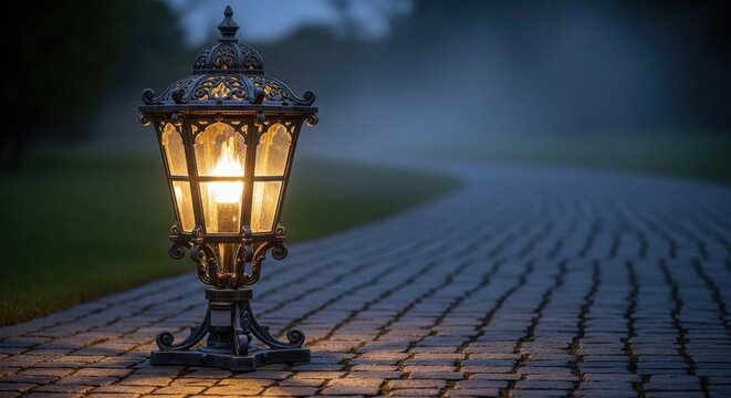 Ornate vintage cast iron lantern illuminates a cobblestone path at dusk, casting a warm glow.