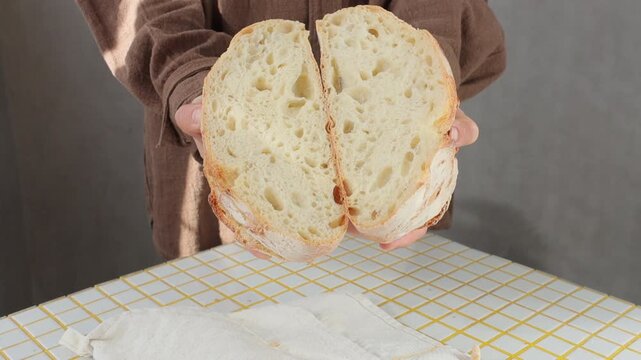 person is holding white bread in hands. homemade sourdough bread with crispy crust. Bakery products. yeast-free sourdough bread. healthy and healthy food. bakery. health care, gluten-free farm flour.