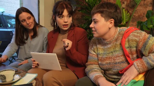 Creative Team Collaborating Together using tablet - business meeting in a cozy coffee