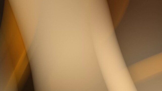 Abstract dynamic light streaks flowing in motion. Blurred golden illumination moving across brown backdrop. Natural earthy colors animation background.