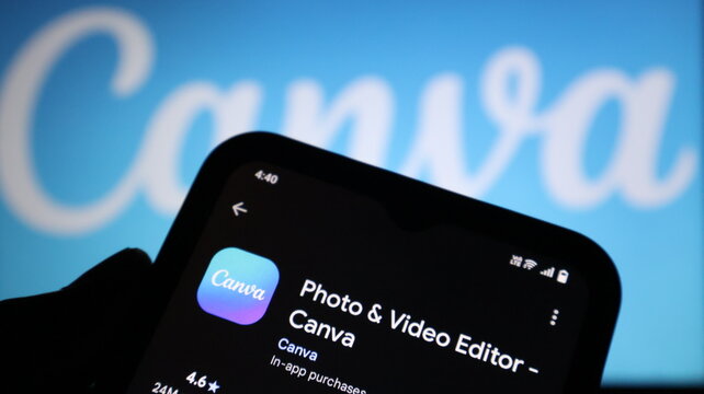 A hand holding a smartphone with the Canva app open on the screen