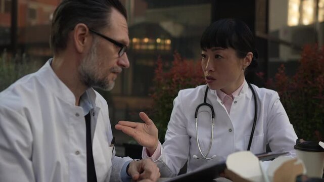 Two doctors discussing patient case during lunch break