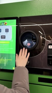 Returning plastic bottles to recycling machine in supermarket