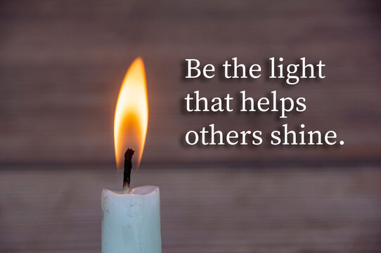 Be the light that helps others shine, Warm candle quote composition on wood background symbolizing encouragement, support, and shared brightness.
