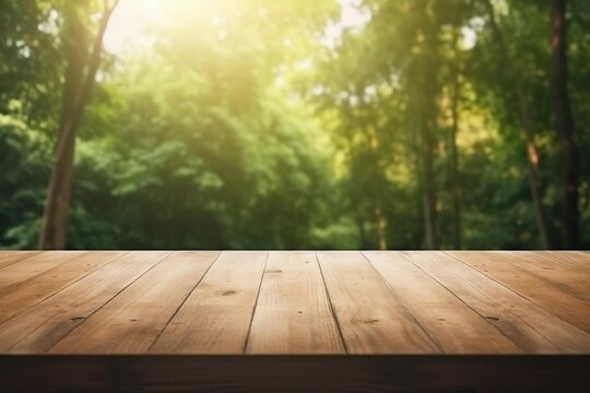 Empty wooden table with blurred green forest and soft sun flare providing a nature background