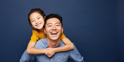 Obraz premium Father and daughter sharing piggyback in colorful studio setting