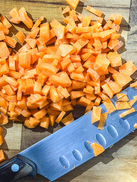 Cubes of carrot, on a wooden cutboard.