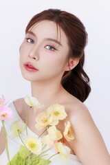 Fototapeta premium Beauty portrait of Asian woman with healthy radiant skin holding flower, aesthetic clinic and cosmetic treatment concept.