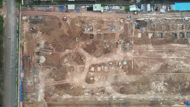 Aerial view of a large construction site featuring excavators, heavy machinery, and foundation work on brown earth in An Phuoc, Dong Nai, Vietnam.
