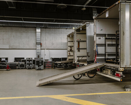 Professional Touring Equipment Cases on Loading Ramp During Event Logistics Setup in Industrial Warehouse Environment