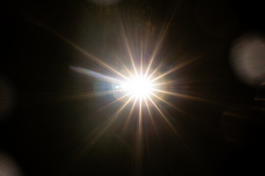 Easy to add lens flare effects for overlay designs or screen blending mode to make high-quality images. Abstract sun burst, digital flare, iridescent glare over black background.