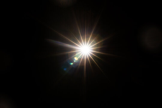 Easy to add lens flare effects for overlay designs or screen blending mode to make high-quality images. Abstract sun burst, digital flare, iridescent glare over black background.