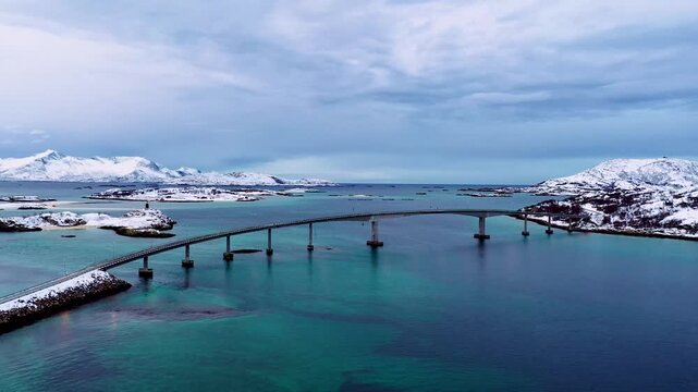 Stabile Drohnenaufnahme von Inseln mit Br&uuml;cke im winterlichen Nordnorwegen und t&uuml;rkisfarbenem Meer
