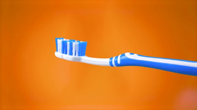 A close-up 3D animation of a blue and white toothbrush against a vibrant orange backdrop. Ideal for dental hygiene commercials, morning routine videos, and healthcare presentations.