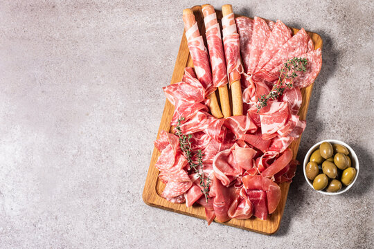 Charcuterie board. Antipasti appetizers of meat platter with salami, prosciutto crudo or jamon and olives.