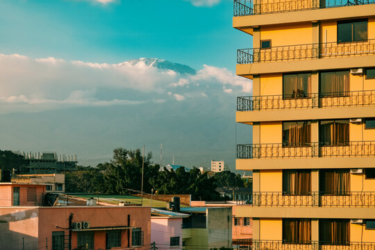 Mount Kilimanjaro peak rising above the urban skyline of Moshi Town at sunrise, Tanzania